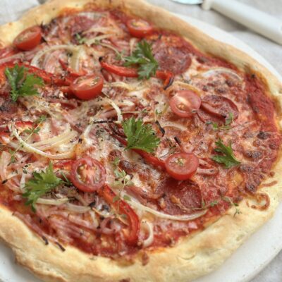 Hjemmelavet pizza med surdej, pepperoni, skinke og grønt