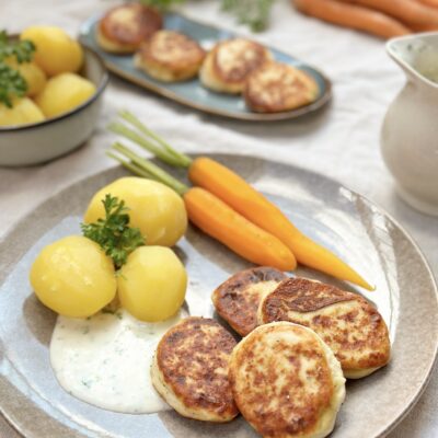 Fiskefrikadeller med nye kartofler, gulerødder og persillesovs